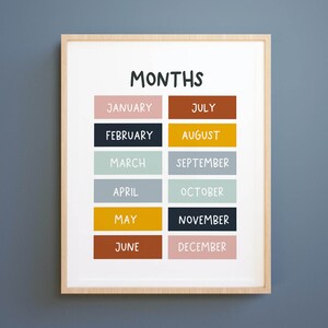 May include: A printable chart with the months of the year listed in a grid. Each month is written in white text on a coloured rectangle. The colours are pink, dark blue, light blue, grey, yellow, brown, gold, black, light green, and light pink.