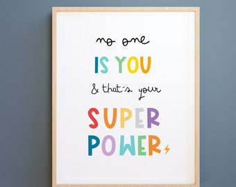 May include: A framed print with the text "no one is you & that's your super power" in colorful letters with a lightning bolt.