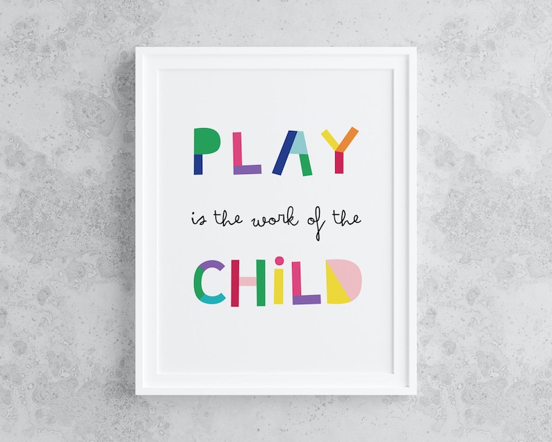 May include: A white framed print with the text "PLAY is the work of the CHILD" in colorful, geometric letters.