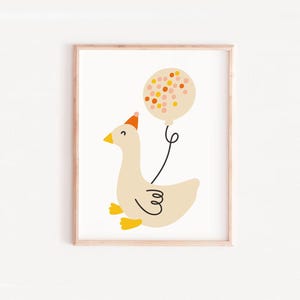 May include: A white goose wearing a party hat holds a pink and orange confetti balloon. The goose is smiling and has yellow feet. The balloon is tied to the goose's neck with a string.