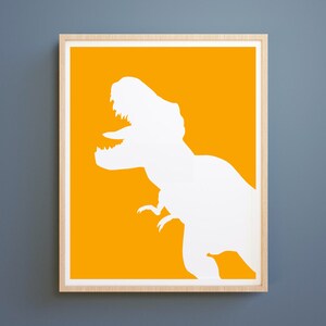 May include: A framed print with a white silhouette of a Tyrannosaurus Rex on a bright yellow background.