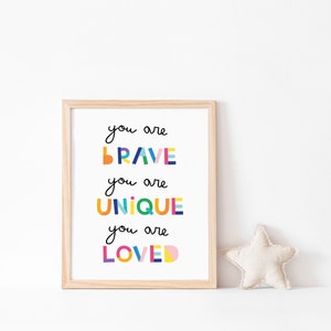 May include: A framed print with the text "You are brave, you are unique, you are loved" in colorful, geometric letters. The print is on a white background and has a light wood frame.