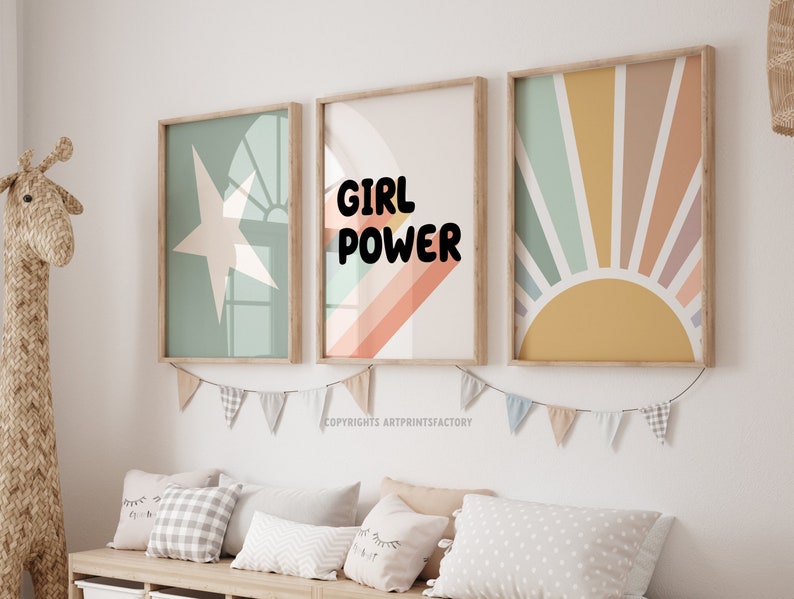 May include: Three framed prints with a pastel colour scheme. The centre print features the text "GIRL POWER" in black bold letters with a rainbow stripe design. The print on the left features a white star on a light green background. The print on the right features a yellow sun with a rainbow stripe design.