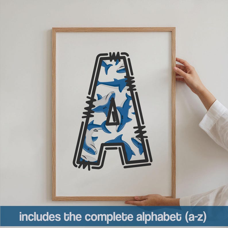 Puede incluir: Impresi&oacute;n enmarcada con la letra "A" llena de tiburones de dibujos animados azules y blancos. La letra est&aacute; delineada en negro con un borde decorativo. El texto en la parte inferior dice "includes the complete alphabet (a-z)".