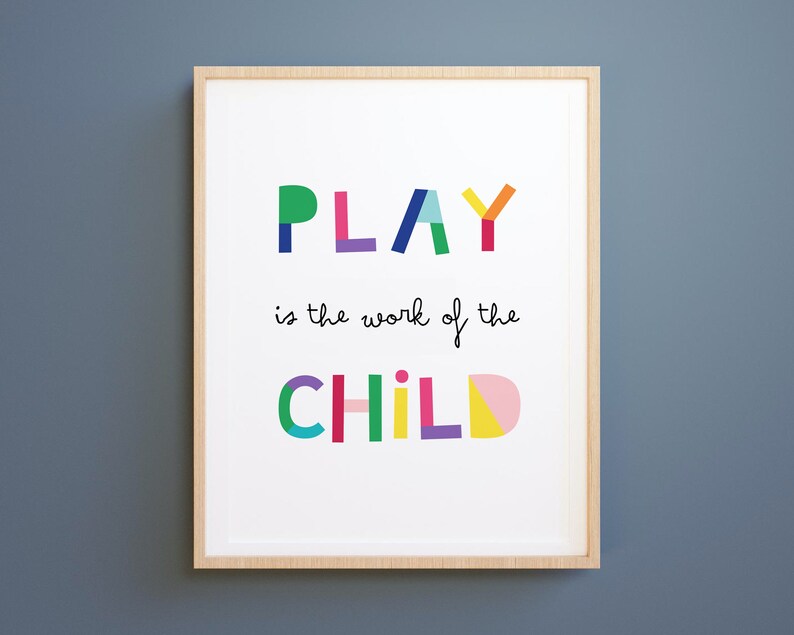 May include: A framed print with the text "PLAY is the work of the CHILD" in colorful, geometric letters. The letters are made up of different colored shapes.