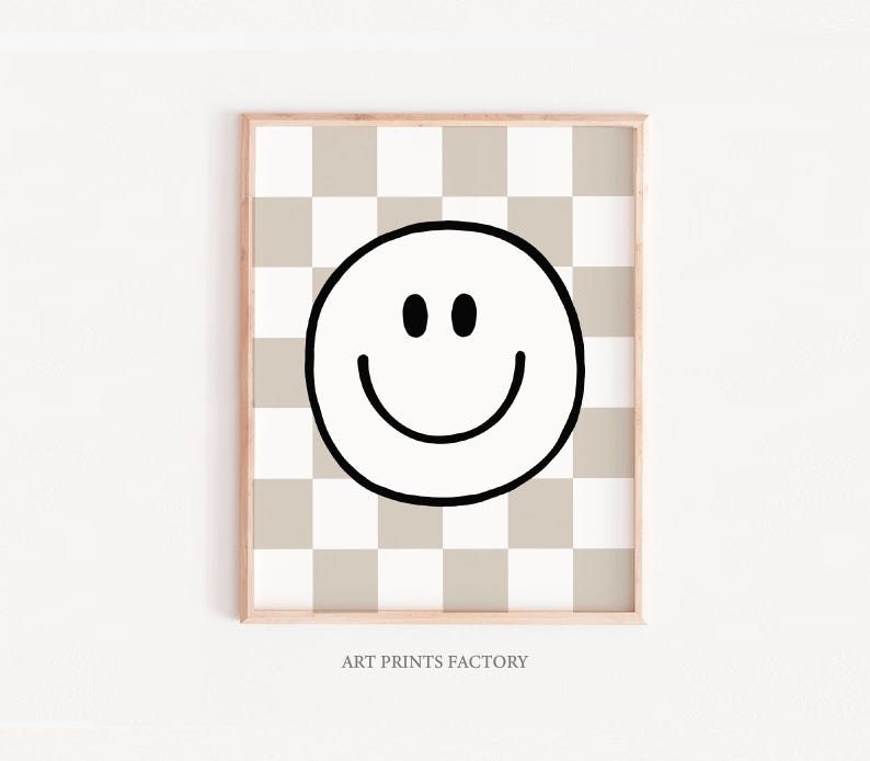 Op de afbeelding: Een zwart-witte smiley-gezichtsgrafiek op een beige en witte geruite achtergrond. De grafiek is gecentreerd op de print. De print heeft een houten frame. De tekst "ART PRINTS FACTORY" staat onderaan de print.
