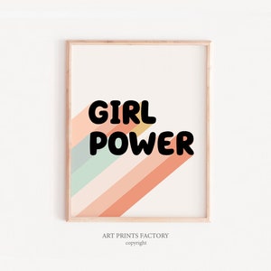 May include: A framed print with a colourful striped background and the text "GIRL POWER" in black bold letters. The print has a light wood frame.