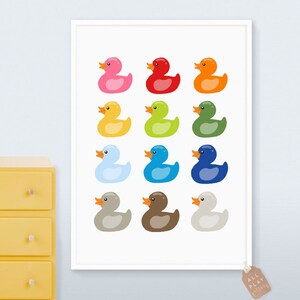 Pu&ograve; includere: Una stampa incorniciata bianca con una disposizione colorata di 12 paperelle di gomma. Le paperelle sono di vari colori, tra cui rosa, rosso, arancione, giallo, verde, blu, azzurro, grigio, marrone e bianco.