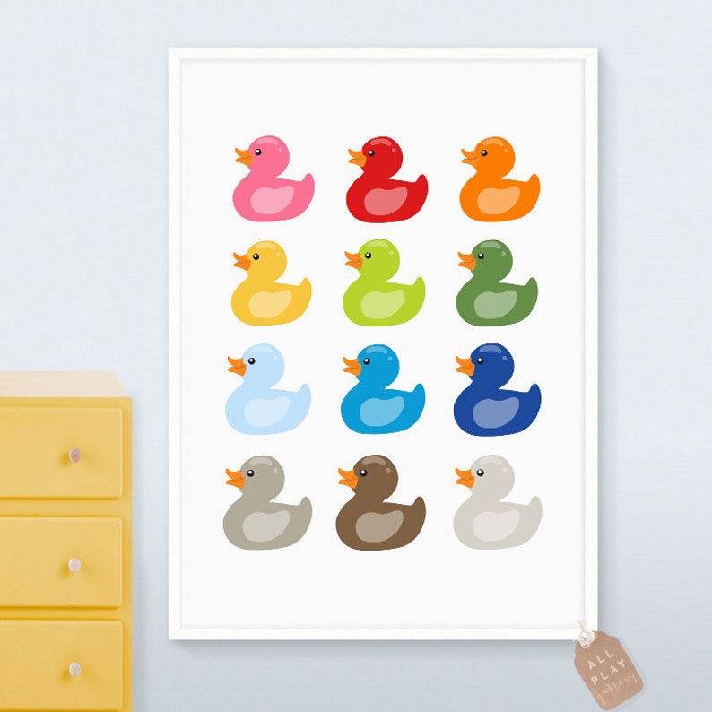 Pu&ograve; includere: Una stampa incorniciata bianca con una disposizione colorata di 12 paperelle di gomma. Le paperelle sono di vari colori, tra cui rosa, rosso, arancione, giallo, verde, blu, azzurro, grigio, marrone e bianco.