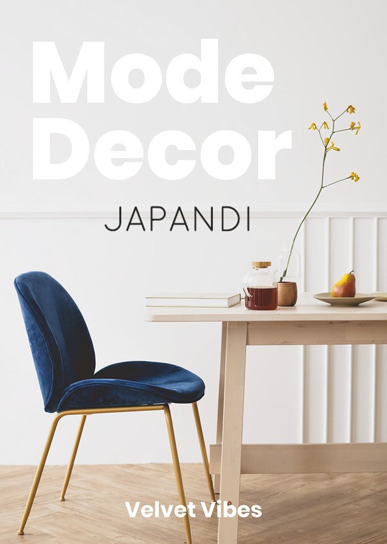 May include: A blue velvet chair with gold legs sits in front of a wooden table with a vase of yellow flowers, a book, and a glass jar with a brown liquid. The text "Mode Decor" and "Japandi" is written on the wall behind the table. The text "Velvet Vibes" is written on the floor in front of the chair.