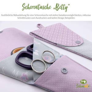 Puede incluir: Una funda para tijeras de tela gris y rosa con un patrón floral. La funda tiene un cierre de botón y está diseñada para guardar tijeras y otras pequeñas herramientas de costura. El texto "Scherentasche "Betty" es visible en la parte superior de la imagen.