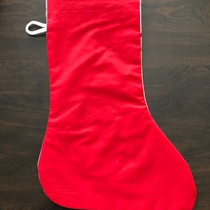 K&ouml;nnte beinhalten: Ein roter Weihnachtssocken mit wei&szlig;em Besatz und einer wei&szlig;en Schlaufe oben.