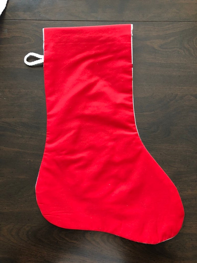 K&ouml;nnte beinhalten: Ein roter Weihnachtssocken mit wei&szlig;em Besatz und einer wei&szlig;en Schlaufe oben.