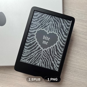 Peut inclure: Une liseuse noire affichant un fond à motif zébré gris et noir avec un cœur bordé de dentelle blanche contenant le texte bite me. Sous l'appareil se trouvent deux petites étiquettes grises avec le texte 1 EPUB et 1 PNG, près d'un ordinateur portable argenté.
