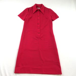 May include: A short-sleeved dress in a vibrant red hue featuring a pattern of thin, horizontal black stripes. The garment includes a pointed collar, a central button-down placket with five visible buttons, and a straight, knee-length hemline.