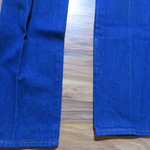 May include: A pair of blue denim jeans with a wide leg opening. The jeans have a straight leg fit and are made of a soft, comfortable fabric.