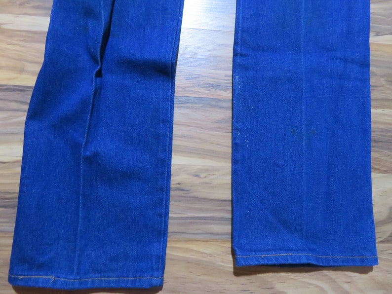May include: A pair of blue denim jeans with a wide leg opening. The jeans have a straight leg fit and are made of a soft, comfortable fabric.