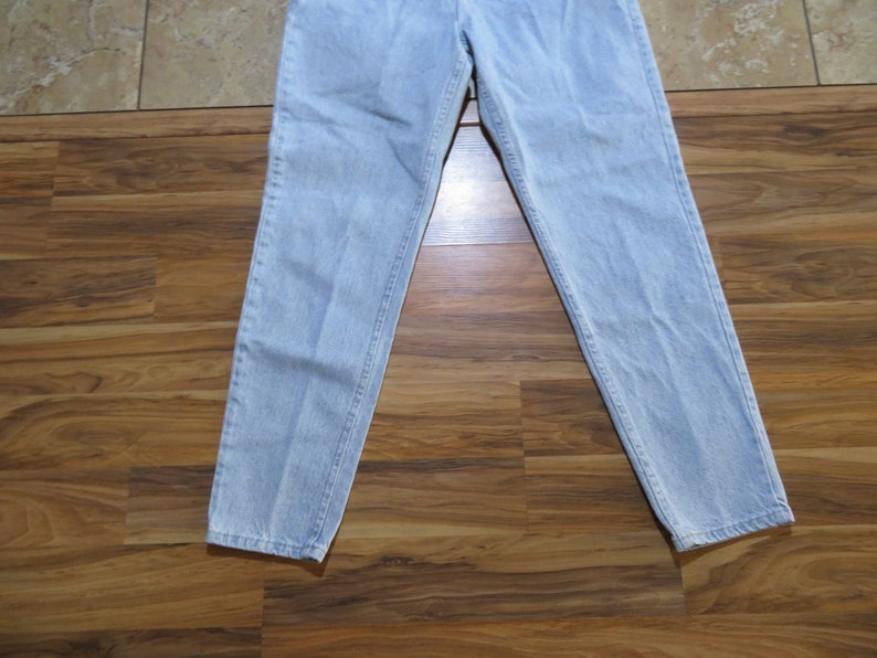 May include: Light blue denim jeans with a straight leg fit.