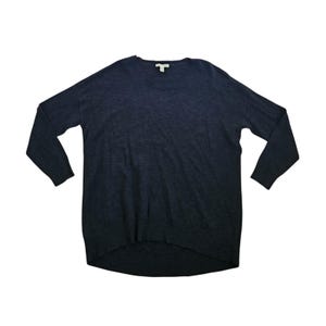 May include: A dark navy blue long-sleeve sweater featuring a round neckline, a ribbed collar, and a high-low hemline. The knit garment has a subtle heathered texture throughout, with long sleeves and a relaxed fit, showcasing a simple design.