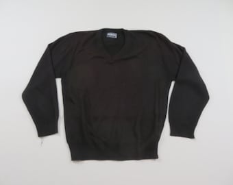May include: A black V-neck sweater with long sleeves. The sweater is made of a soft material and has a ribbed hem and cuffs. The neckline has a small tag.