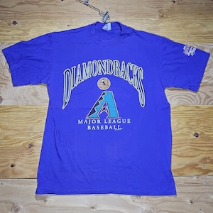 May include: A purple t-shirt with the words "Diamondbacks" in a white arc above a blue and green baseball team logo. The text "Major League Baseball" is below the logo.