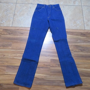 May include: A pair of blue denim jeans with a straight leg fit. The jeans have a classic five-pocket style and a button fly.
