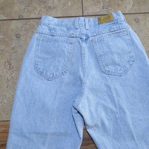 May include: A pair of light blue denim jeans with a back pocket on each side. The jeans have a brown leather patch with the word "Lee" on it.
