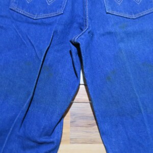 May include: A pair of blue denim jeans with a faded look. The jeans have a straight leg and a classic five-pocket design.