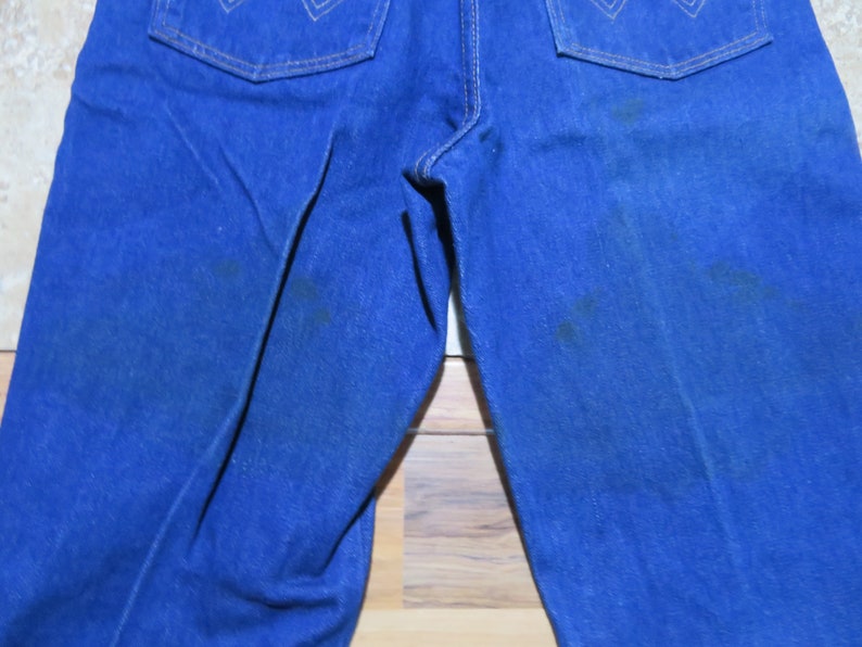 May include: A pair of blue denim jeans with a faded look. The jeans have a straight leg and a classic five-pocket design.