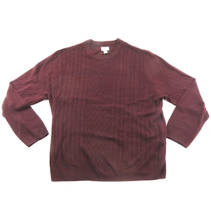 May include: A long-sleeved crew neck sweater in a deep burgundy color. The front panel features a textured knit pattern consisting of vertical cable knit columns flanking a central diamond lattice design, while the sleeves remain plain.