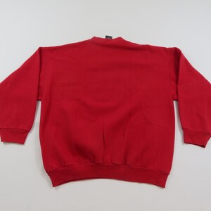 Puede incluir: Una sudadera roja lisa de manga larga. La sudadera de cuello redondo est&aacute; hecha de un material suave. Los pu&ntilde;os y el dobladillo son acanalados. La prenda se muestra sobre un fondo blanco.