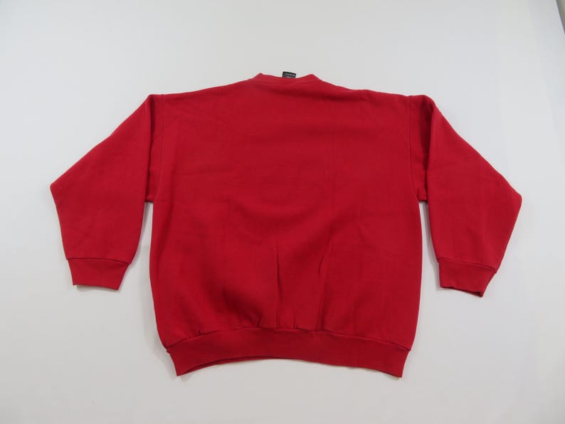 Puede incluir: Una sudadera roja lisa de manga larga. La sudadera de cuello redondo est&aacute; hecha de un material suave. Los pu&ntilde;os y el dobladillo son acanalados. La prenda se muestra sobre un fondo blanco.