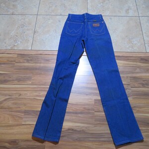 May include: A pair of blue denim jeans with a brown leather patch on the back pocket that says "Wrangler".