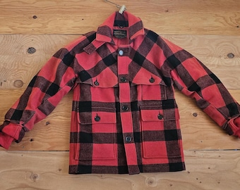 May include: A red and black plaid flannel jacket with a button closure and two large pockets. The jacket has a collar and is made of a thick, warm fabric.