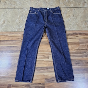 May include: Dark blue denim jeans with a classic five-pocket design. The jeans have a straight leg cut and are made of a sturdy denim material. The jeans are shown from a top-down perspective.