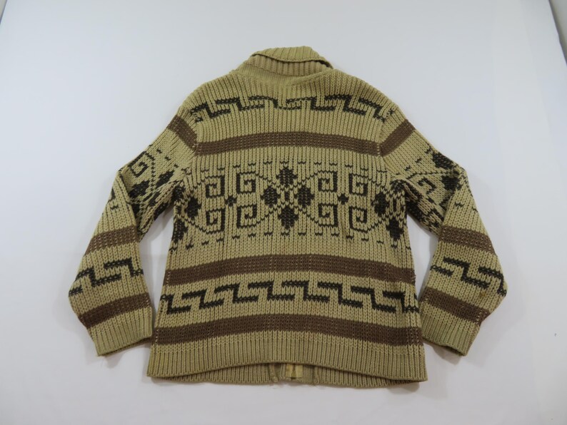 Puede incluir: C&aacute;rdigan de punto beige y marr&oacute;n con un patr&oacute;n geom&eacute;trico. El c&aacute;rdigan presenta un cuello, mangas largas y cierre de cremallera completo. El dise&ntilde;o incluye rayas horizontales y formas geom&eacute;tricas detalladas.