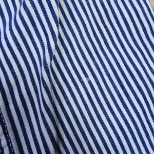 May include: Close-up of a white and blue striped fabric with a diagonal pattern. The fabric is soft and textured.