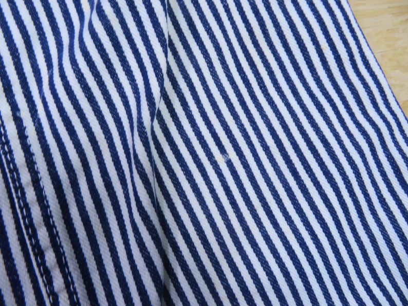 May include: Close-up of a white and blue striped fabric with a diagonal pattern. The fabric is soft and textured.