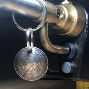May include: A silver key chain with a 2007 Idaho state quarter attached. The quarter features a bald eagle and the words "Idaho 1890 Esto Perpetua" and "E Pluribus Unum".