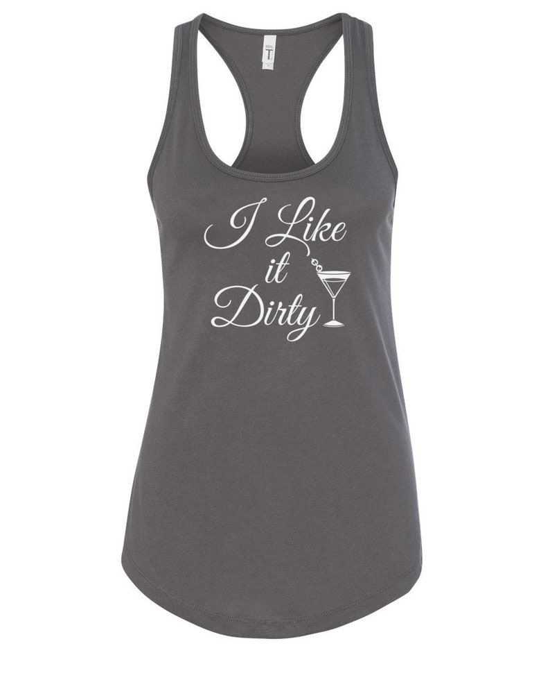 May include: A dark gray racerback tank top with the phrase "I Like it Dirty" in white script, accompanied by a martini glass graphic. The tank top has a scoop neck and a curved hemline.