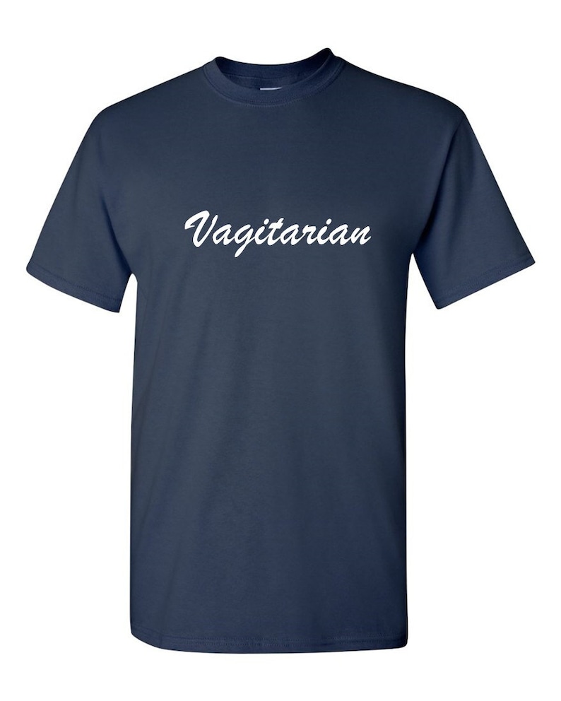 May include: Navy blue t-shirt with the word "Vagitarian" in white script across the chest. The short-sleeved shirt is made of a soft material and has a crew neck.