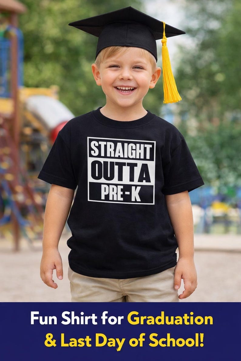 May include: A young child wearing a black graduation cap with a yellow tassel and a black t-shirt. The shirt has the text "STRAIGHT OUTTA PRE-K" in a white box. The child is smiling and wearing khaki pants.