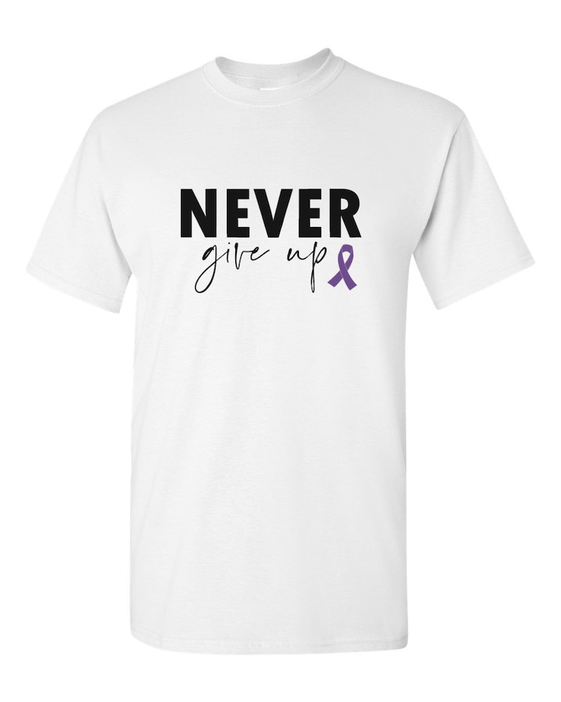 Puede incluir: Camiseta blanca con el texto "NEVER give up" en letras negras y una cinta morada.