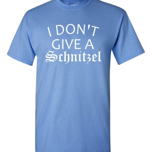 May include: A light blue t-shirt with the text "I don't give a Schnitzel" printed in white.