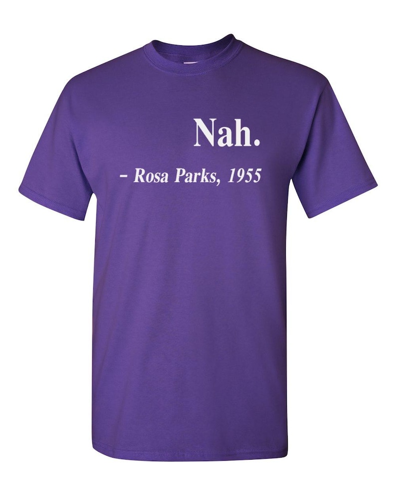 May include: A purple t-shirt with the text "Nah." above "- Rosa Parks, 1955" in white lettering. The shirt has short sleeves and a crew neck.