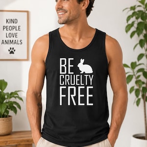 May include: Black tank top with the words "BE CRUELTY FREE" in white block letters and a white rabbit graphic. A framed print with the words "KIND PEOPLE LOVE ANIMALS" hangs on the wall.