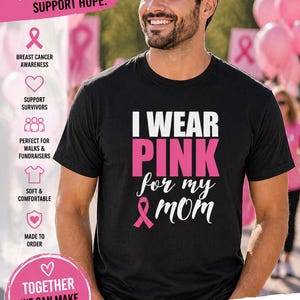 May include: Black t-shirt with the text "I WEAR PINK for my MOM" in white and pink. The shirt also features a pink ribbon graphic, symbolizing breast cancer awareness. The shirt is made of a soft and comfortable material.