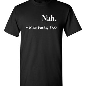May include: Black t-shirt with the white text "Nah." and "- Rosa Parks, 1955" printed on the front. The shirt is a crew neck style and appears to be made of cotton or a similar fabric.