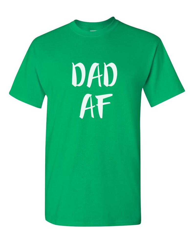 Peut inclure: T-shirt vert vif avec l'inscription blanche "DAD AF" dans un style manuscrit. Le t-shirt a des manches courtes et un col rond.