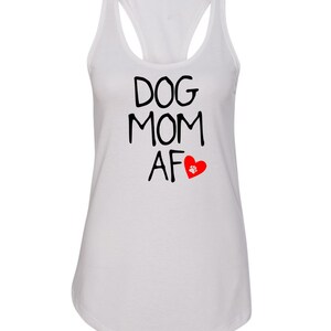 May include: White tank top with a racerback design. The shirt features the text "DOG MOM AF" in black, with a red heart and paw print graphic. A casual and comfortable top for dog lovers.